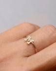A gold ring with a simple, raised letter "M" on the band.