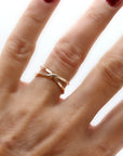 Gold X wrap ring with hammered texture worn on a woman&