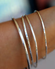 Hammered Silver Bracelets on the wrist.
