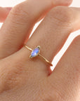 A gold ring with a marquise-shaped moonstone set in the center. The ring is on a person&