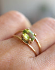 A gold ring with a green oval gemstone set in a double band design.