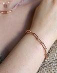 Rose gold paperclip chain bracelet. The bracelet is made of elongated, rectangular links. A matching rose gold necklace is also visible in the image.