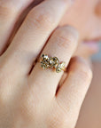 A gold ring with a floral design featuring several small flowers and leaves.