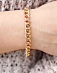 A gold chain bracelet with a curb link design.