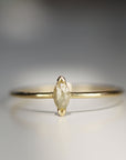 A gold ring with a marquise shaped diamond in the center.
