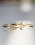 Two gold rings with marquise shaped diamonds. The diamonds are a light brown color and have a faceted cut.