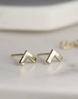 A pair of gold chevron shaped stud earrings