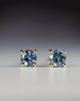 14k solid gold stud earrings with round blue Montana sapphires, displayed on a white background as bridal or birthday gemstone jewelry.