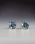 14k solid gold stud earrings with round blue Montana sapphires, displayed on a white background as bridal or birthday gemstone jewelry.