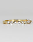 Floating Diamond Wedding Ring. It is Shared Prong Eternity Ring which is Stackable. A gold band with a row of small, round, clear diamonds set in the band.