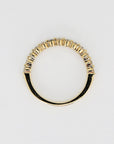 A gold band ring with a row of small, clear diamonds set in the band.