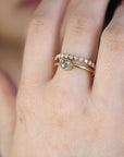wo gold rings with diamonds. The top ring has a single round, bezel-set diamond. The bottom ring has a row of small, round diamonds.
