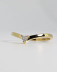 A curved gold band ring with a single, small, triangular diamond set in the center.