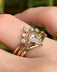 Three gold rings with diamonds. The center ring has a large, round, rose-cut diamond. The two outer rings have smaller diamonds set in a crescent shape.