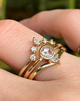 Three gold rings with diamonds. The center ring has a large, round, rose-cut diamond. The two outer rings have smaller diamonds set in a crescent shape.