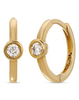 A pair of gold hoop earrings with a single clear diamond in each hoop.