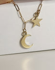 A gold chain necklace with a crescent moon and star charm.