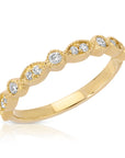 A delicate gold band ring with a row of small, round diamonds set in a scalloped design.