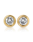 A pair of gold stud earrings with a round, bezel-set diamond in each earring.