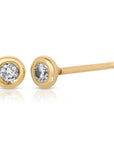 A pair of gold stud earrings with a small round diamond in each earring.