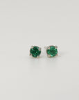 A pair of emerald green emerald earrings with silver settings.