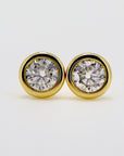 A pair of gold stud earrings with round moissanites