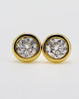 A pair of gold stud earrings with round moissanites