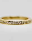 A thin gold band with a row of small diamonds set into the metal.