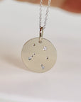 14k white gold zodiac necklace with a round pendant featuring a constellation design with small diamonds