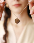 A white gold necklace with a round pendant featuring a constellation design with small diamonds