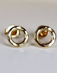 A pair of gold hammered circle stud earrings. The earrings are simple and elegant, and would make a great gift for any occasion.