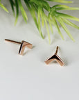 Two gold chevron shaped earrings. The earrings are small and have a simple design.