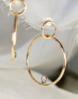 Gold hoop earrings with a small diamond stone in the center of each hoop.