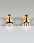 A pair of gold stud earrings with a marquise-shaped diamond in each earring.