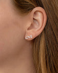 A pair of silver earrings with the word "LOVE" spelled out in small diamonds.