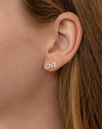 A pair of silver earrings with the word "LOVE" spelled out in small diamonds.