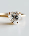 A gold ring with a large heart-shaped moissanite