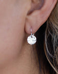 Silver hammered disc earrings with a simple hook closure.