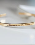 Gold bangle bracelet with the inscription "Love you to the moon and back".