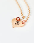 A rose gold necklace with a heart-shaped pendant engraved with the letter "S".