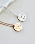 Two delicate necklaces with circular pendants featuring constellation designs. One necklace has a silver chain and a silver pendant with a constellation design. The other necklace has a rose gold chain and a rose gold pendant with a constellation design.