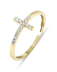 A gold ring with a small, diamond-encrusted cross design. The cross is set on a thin band that is also encrusted with diamonds.