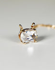 A gold necklace with a large, clear, oval-shaped moissanite pendant.