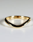 A gold wedding band with a curved, v-shaped design.