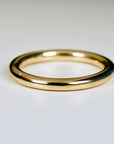 A simple gold wedding band with a smooth, rounded surface.