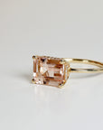 Emerald cut morganite engagement ring with hidden diamond halo in 14k solid gold, blush pink gemstone ring displayed on white background