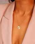 Birth Flower Necklace Gold Filled. A gold chain necklace with a small oval pendant featuring a delicate floral design.