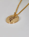 Birth Flower Necklace Gold Filled. A gold chain necklace with a round pendant featuring a delicate engraved floral design.