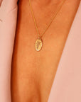 Birth Flower Necklace Gold Filled. A gold chain necklace with an oval pendant featuring a delicate floral design.