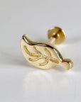 Gold leaf-shaped body jewelry with a textured surface. The jewelry is designed for a piercing and has a post with a small ball on the end.